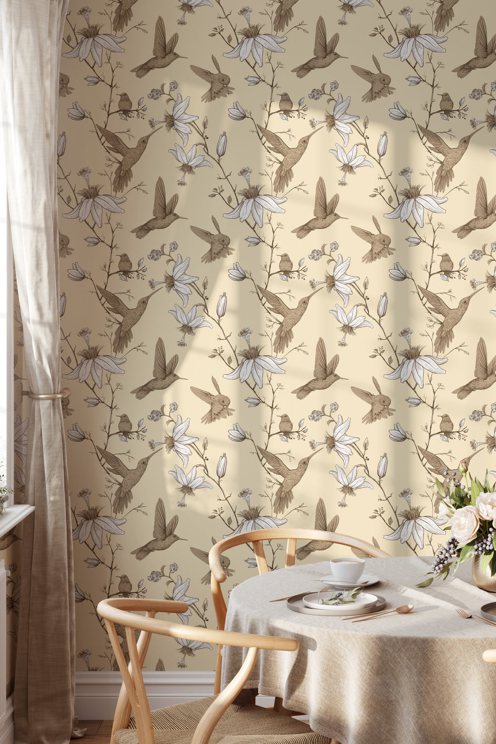 Cozy dining room with wood chairs and round table featuring cream hummingbird botanical floral wallpaper