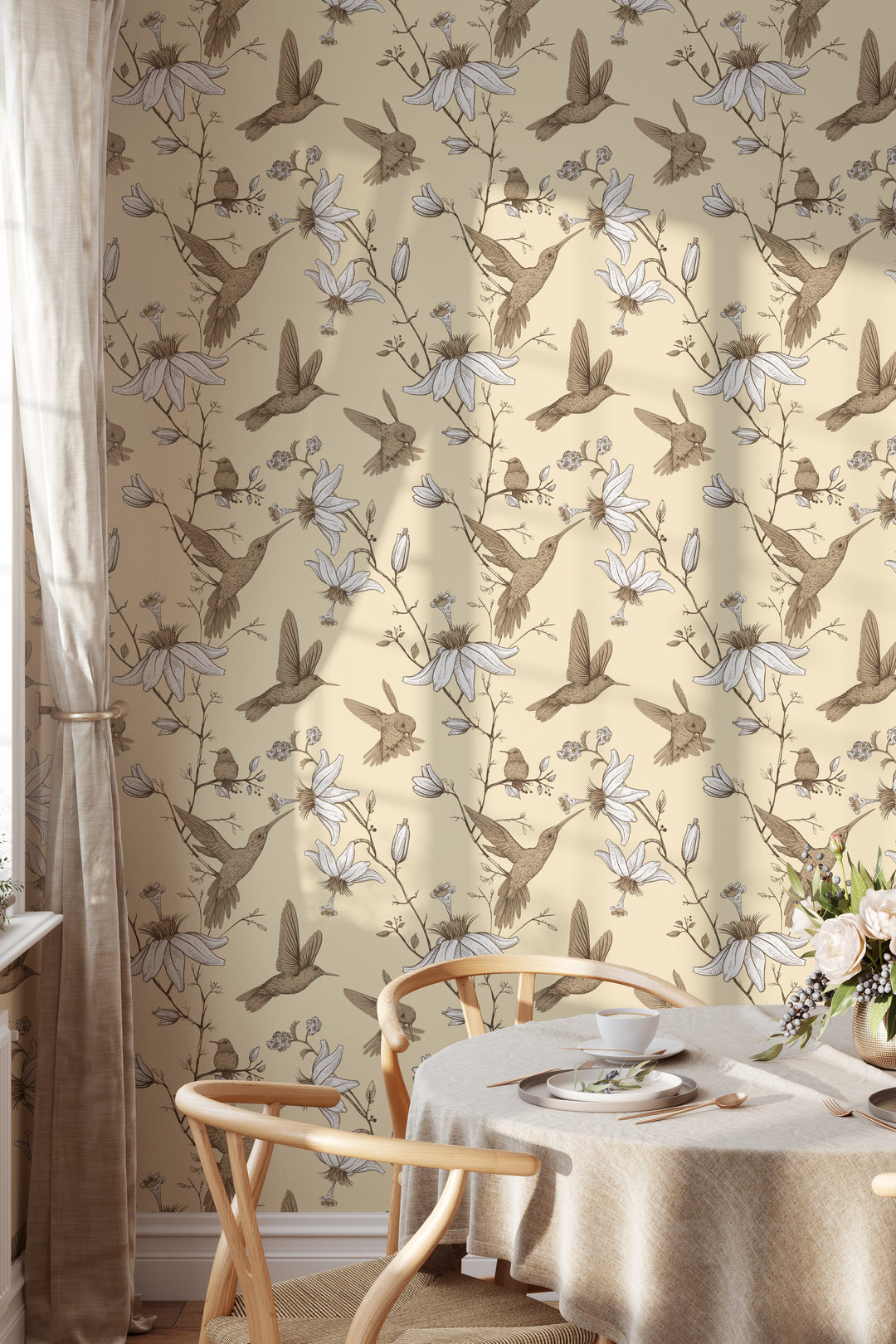 Cozy dining room with wood chairs and round table featuring cream hummingbird botanical floral wallpaper