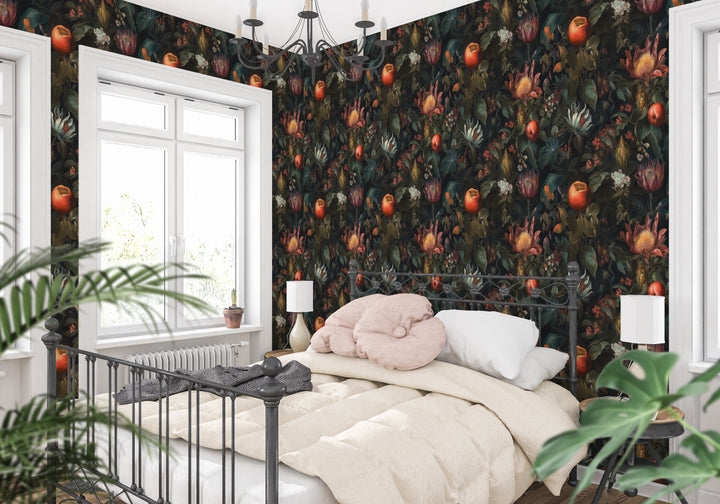 Dark botanical wallpaper with red and orange fruit, exotic flowers, and leafy foliage featured in a bright bedroom with a white bed and black metal frame.