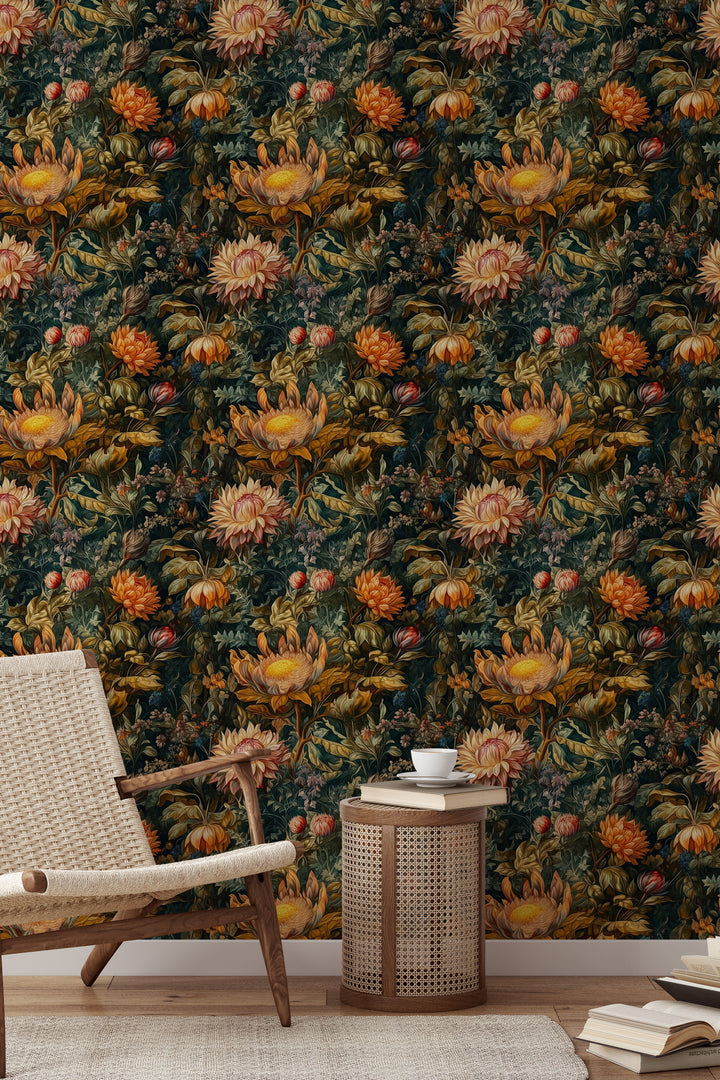 Dark green dahlia wallpaper with orange and cream flowers and lush botanical foliage pattern featured as an accent wall behind a rattan chair and side table.
