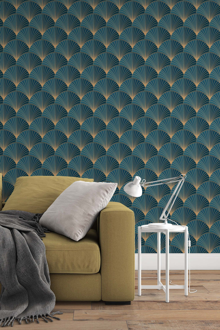 a cozy living room setting with a yellow sofa, a white side table with a lamp, and a patterned wallpaper with a repeating fan-like design in shades of blue and gold.