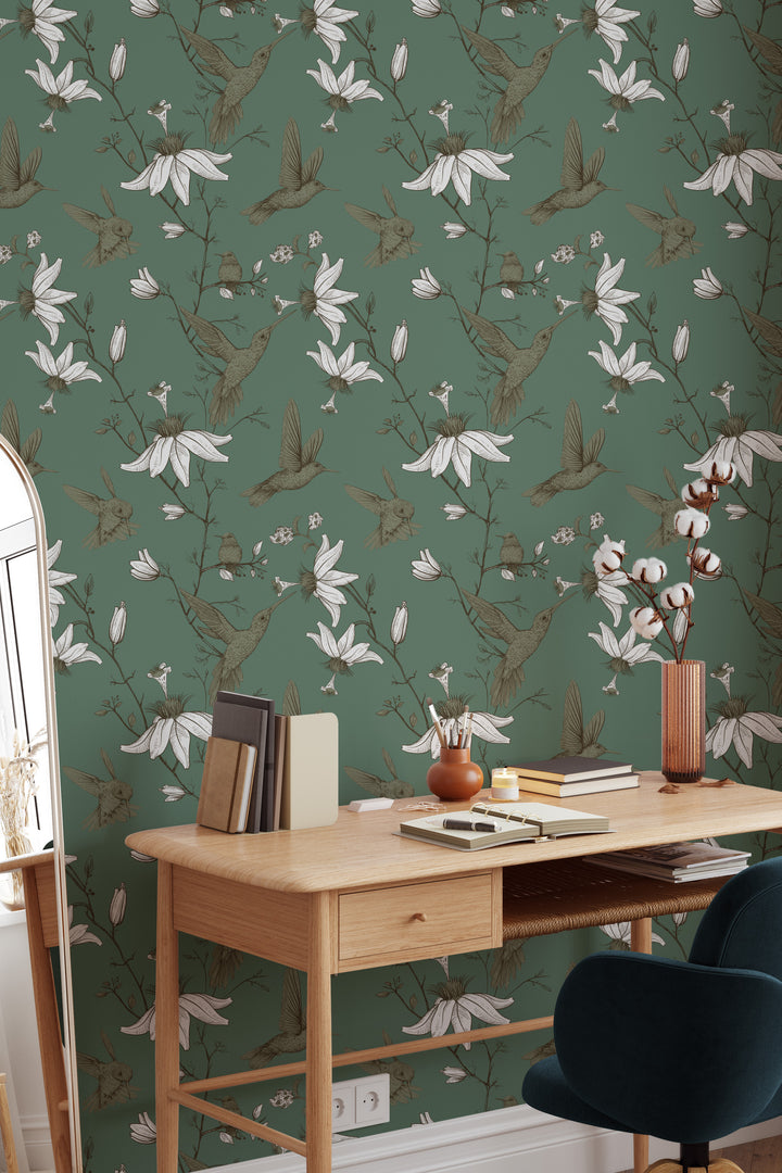 Home office featuring sage green Hummingbird Wallpaper with botanical floral bird pattern, wooden desk, and cozy modern workspace decor