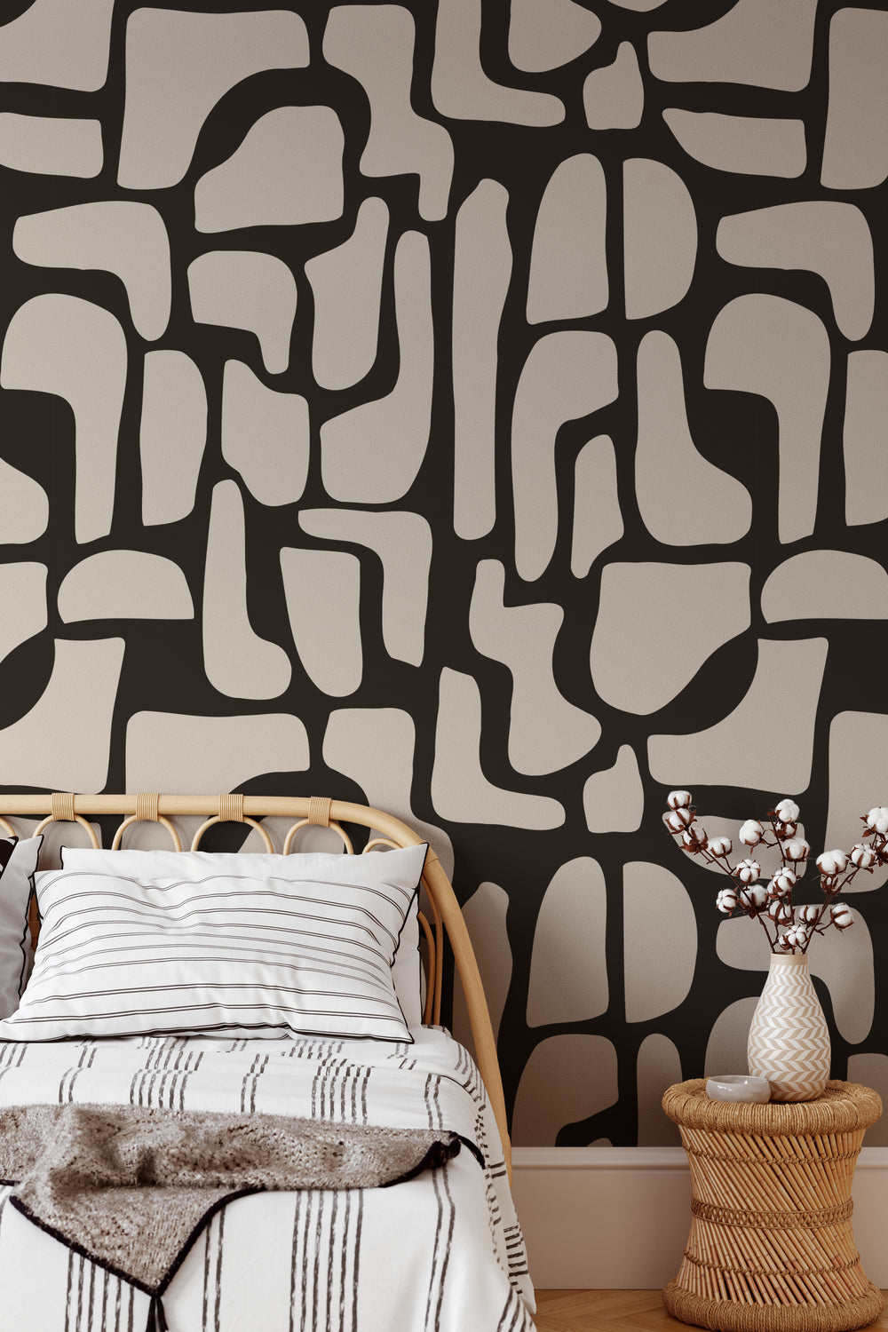 black and beige abstract stone  wallpaper with rattan bed, pillows, and side table