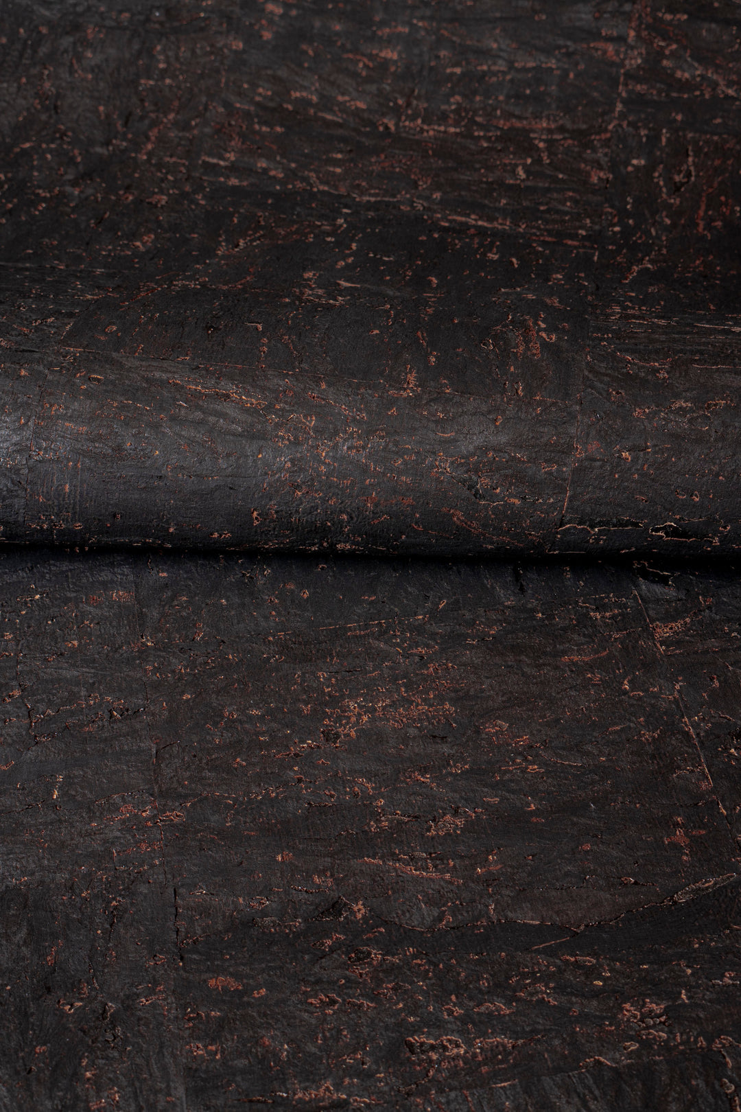 Close-up of dark brown leather with visible texture and wear.