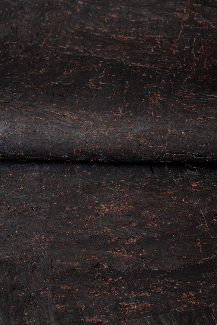 Close-up of dark brown leather with visible texture and wear.