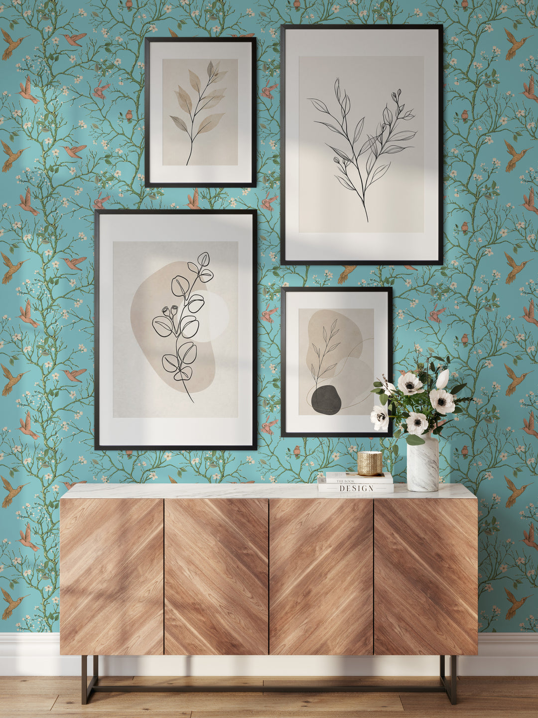 Aqua blue hummingbird wallpaper with flowering branches featured behind a wooden sideboard and framed botanical artwork in a stylish living room.
