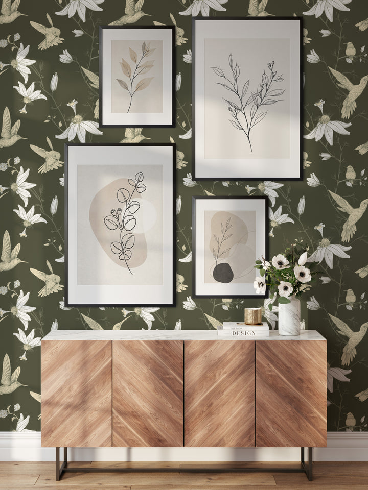 Living room with olive green hummingbird wallpaper featuring a botanical floral bird pattern, framed botanical artwork, and modern wood console decor