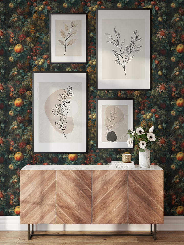 Vintage dark teal and orange botanical wallpaper with fruit and flowers behind a wooden sideboard and framed botanical prints.