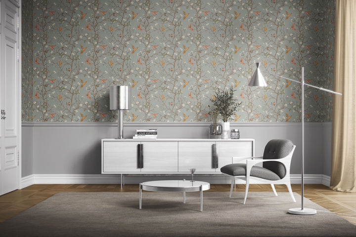 Sage gray hummingbird wallpaper with flowering branches and colorful birds featured as an accent wall in a modern mid-century living room.