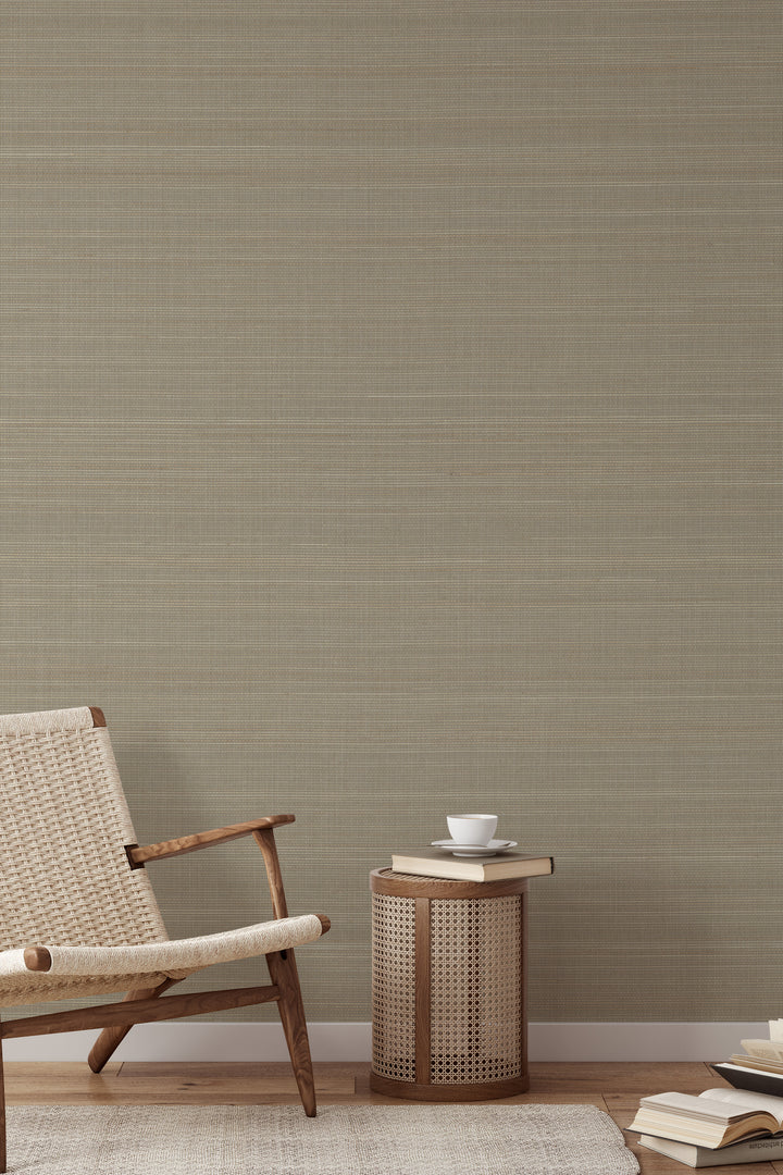 Woven armchair with a book on soft beige faux abaca grasscloth texture