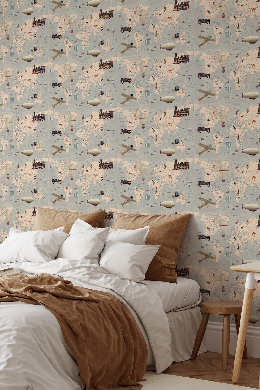 Gray beige world map wallpaper with vintage travel illustrations, airplanes, hot air balloons, and adventure elements in a cozy bedroom