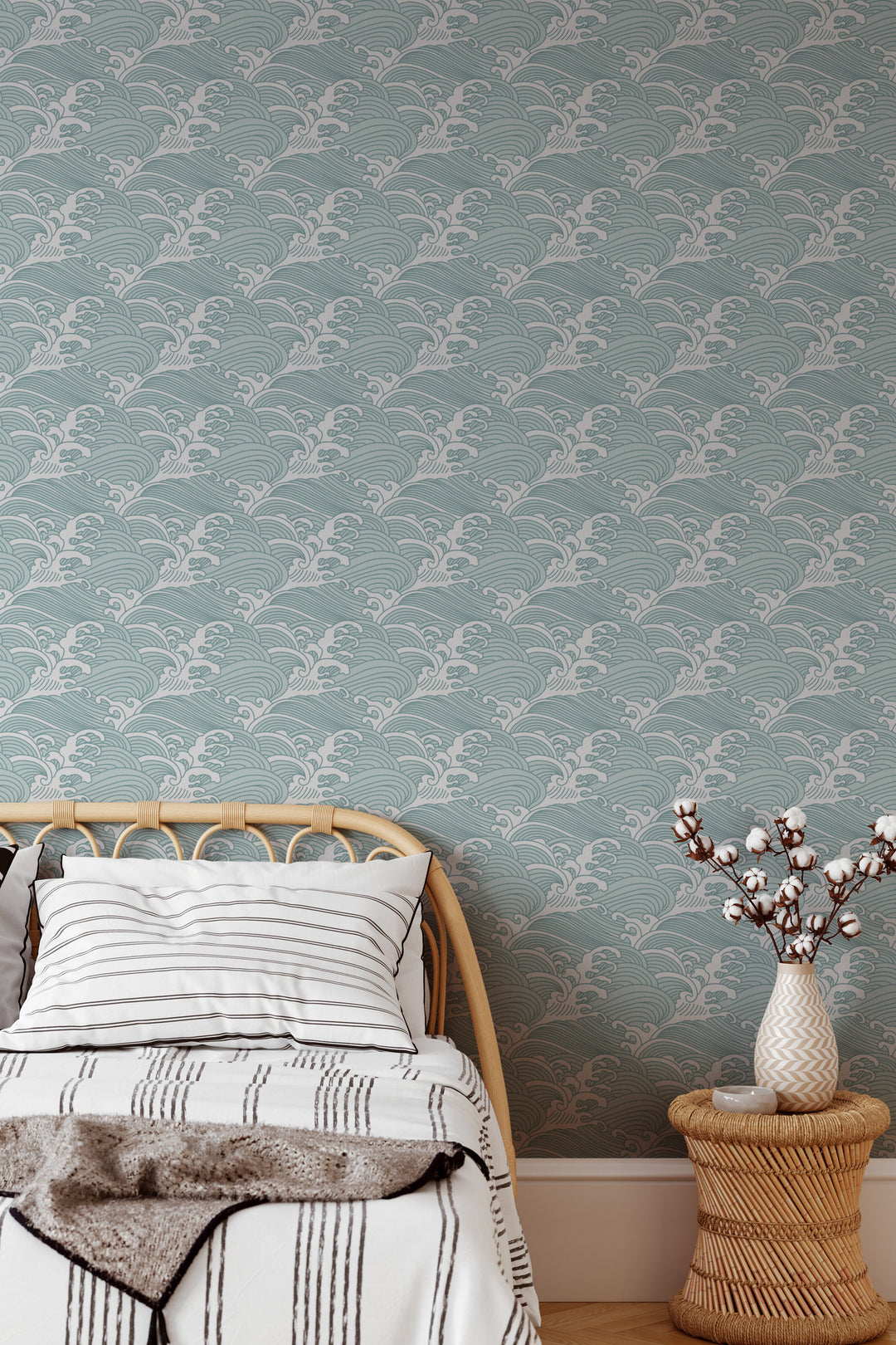 Bedroom with aqua blue Japanese wave wallpaper featuring a traditional ocean pattern and natural rattan decor