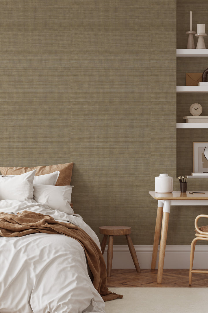 Bedroom interior with bed, pillows, wooden stool, desk and shelves on warm light brown Faux Abaca woven texture wallpaper.