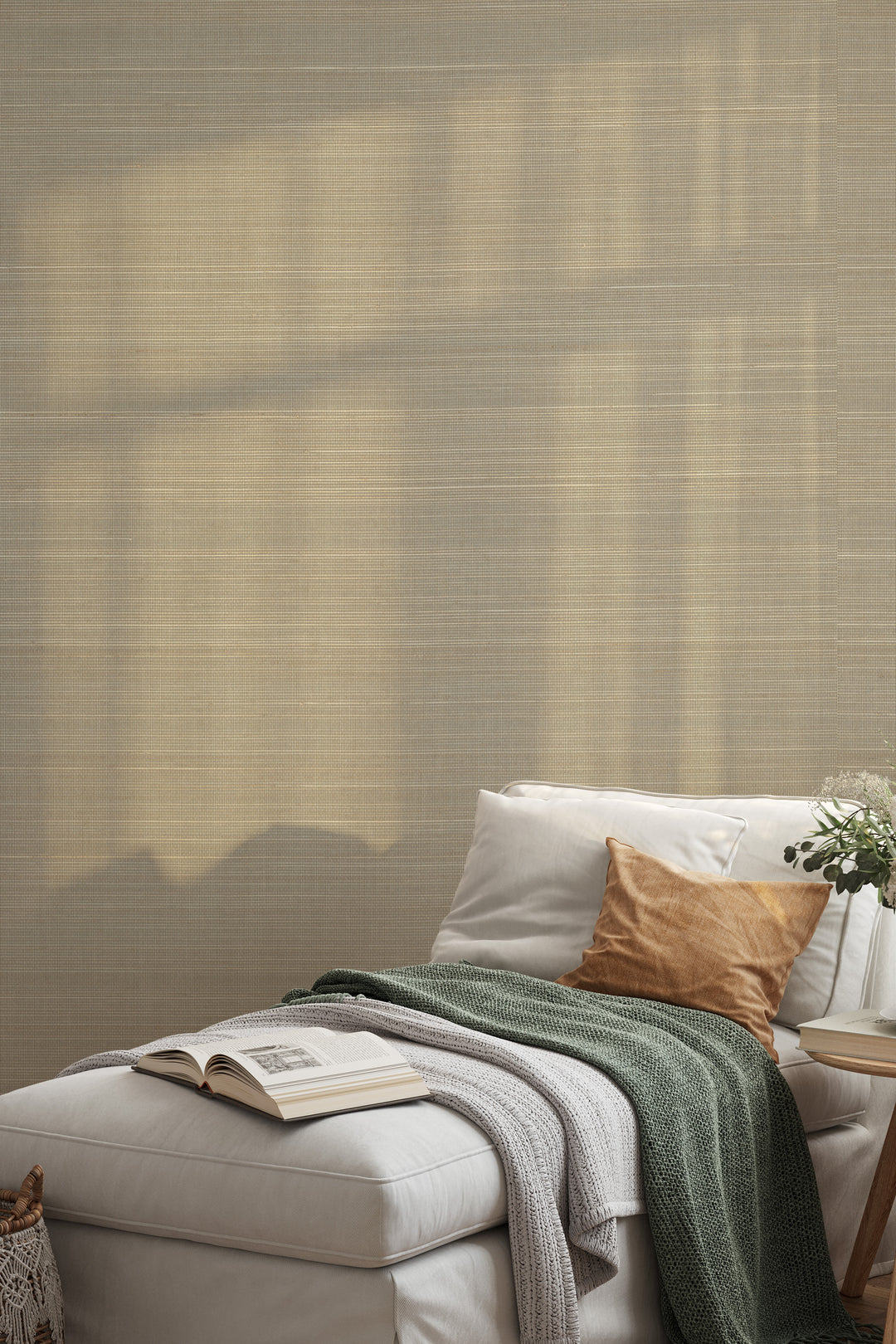 Cozy white couch with textured throw blankets and cushions, next to a woven basket, set against a neutral beige faux abaca grasscloth wallpaper.