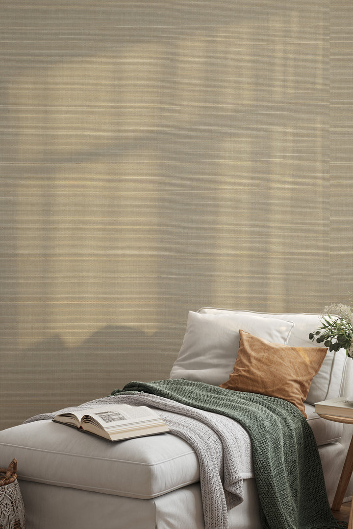 Cozy white couch with textured throw blankets and cushions, next to a woven basket, set against a neutral beige faux abaca grasscloth wallpaper.