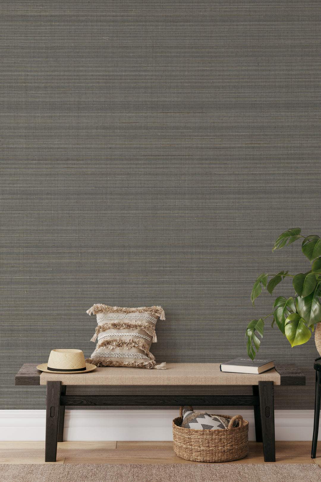 Entryway with woven bench, decorative pillows, basket, and plant against soft gray-beige faux abaca grasscloth wallpaper.