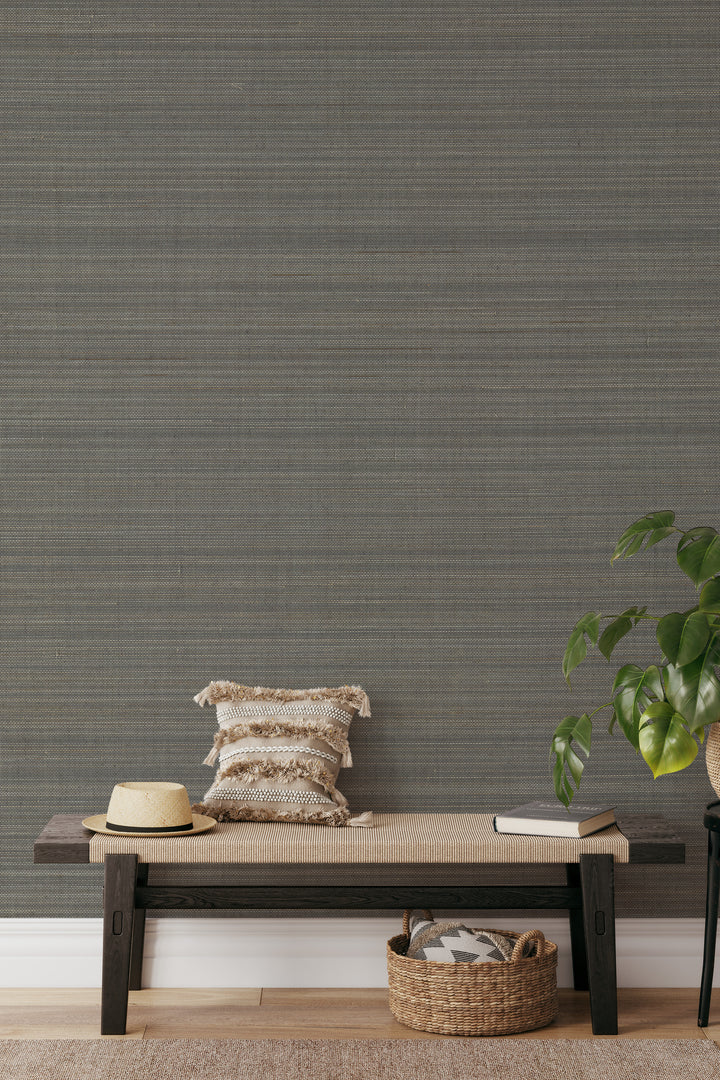 Entryway with woven bench, decorative pillows, basket, and plant against soft gray-beige faux abaca grasscloth wallpaper.