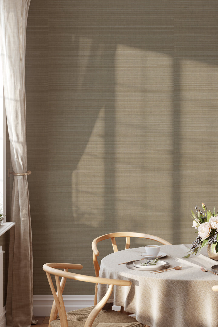 Dining area with round table, woven chairs and flowers on warm light brown Faux Abaca woven texture wallpaper.
