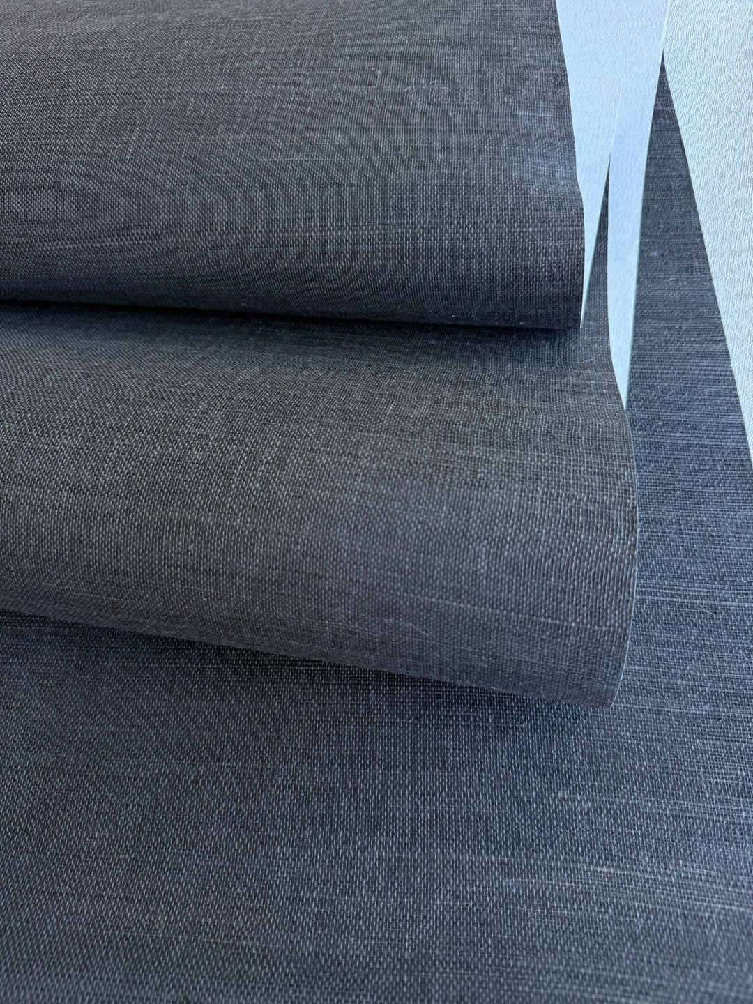 Close-up of gray sisal grasscloth wallpaper with a subtle pattern