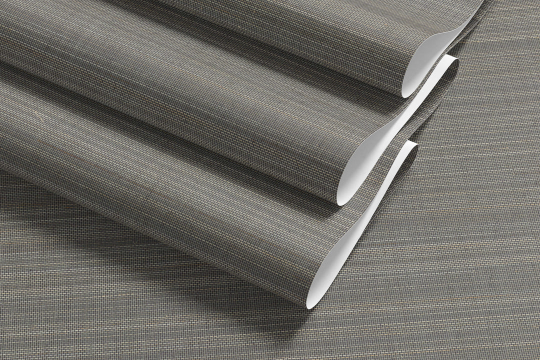 Roll of gray-beige faux abaca grasscloth wallpaper with fine woven grid texture.