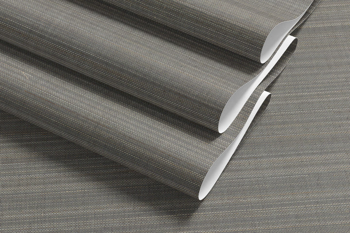 Roll of gray-beige faux abaca grasscloth wallpaper with fine woven grid texture.