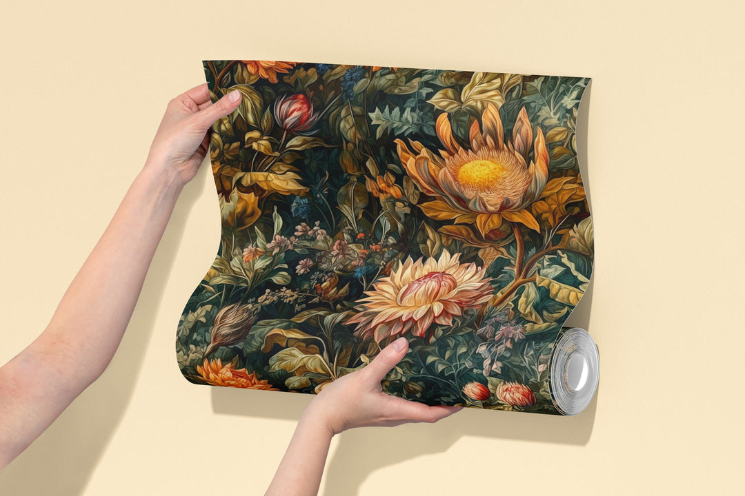 Dark green dahlia wallpaper with vintage orange and cream botanical flowers pattern shown on a wallpaper sample roll