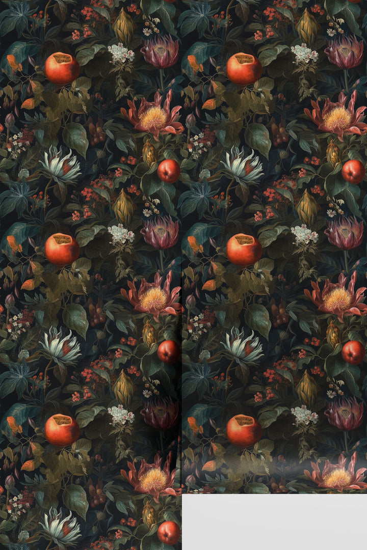 Dark botanical wallpaper featuring red pomegranates, exotic flowers, berries, and lush green foliage on a rolled wallpaper sample.