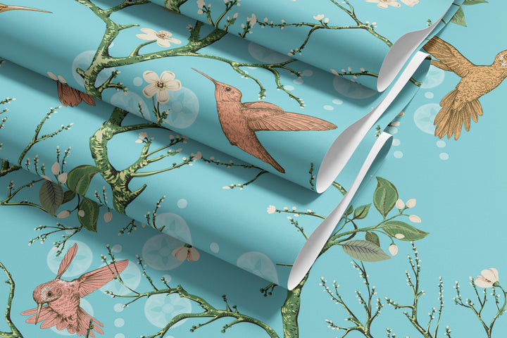 Aqua blue hummingbird wallpaper with birds, flowering branches, and floral details displayed in overlapping rolled sheets.